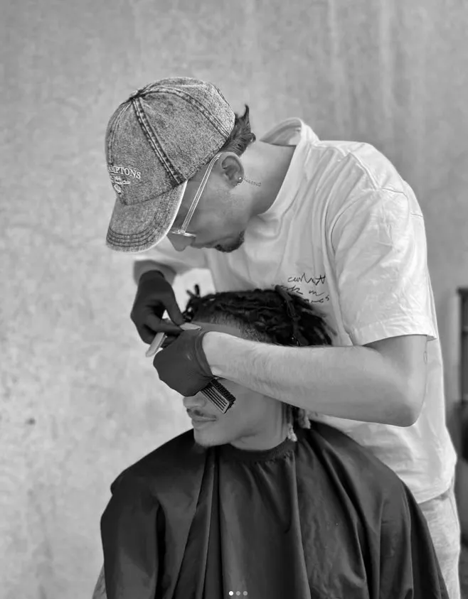 Barbier au travail sur des locks, peigne et tondeuse en main